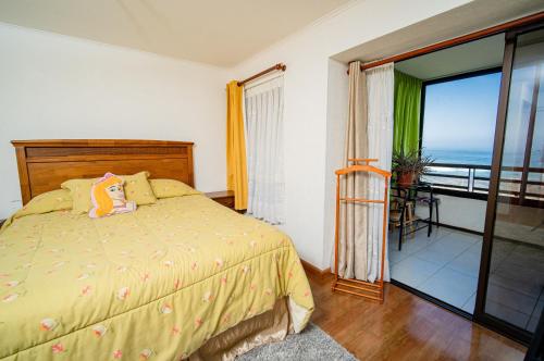 a bedroom with a bed and a view of the ocean at Departamento grande frente a playa Cavancha in Iquique