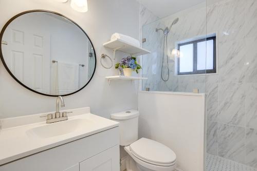 uma casa de banho branca com um WC e um espelho. em Sunny Florida Retreat Near Casinos, Walk to Beach! em Pompano Beach