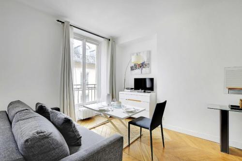 un salon blanc avec un canapé et une table dans l'établissement Authentic apartment - 1BR-2P - Palais Garnier, à Paris