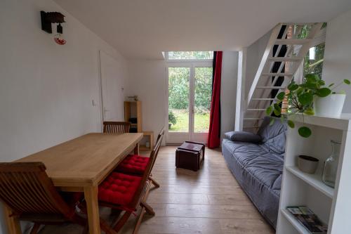 une salle à manger avec une table, des chaises et un canapé dans l'établissement Gites de La Gare - Le Studio, à Plessé