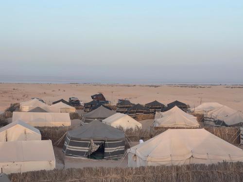 a group of tents in the middle of the desert at Camp Dunes Insolites Sabria in Sabria