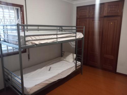 two bunk beds in a room with a window at PRIME ALOJAMNETOS 01 in Gondomar