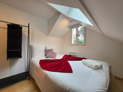 Le Bellevue - Beaux appartements avec vue splendide في باليزو: غرفة نوم مع سرير مع بطانية حمراء عليه