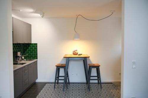 a kitchen with a table and two stools at Green46 in Meerbusch