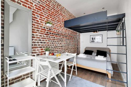 Loft-Apartment mit einem Bett, einem Tisch und Stühlen in der Unterkunft Cozy studio next to Canal Saint-Martin in Paris