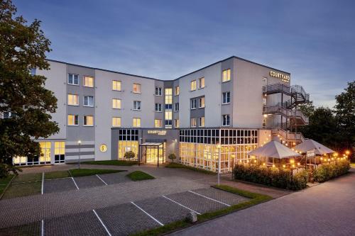 ein Gebäude mit einem Tennisplatz davor in der Unterkunft Courtyard by Marriott Dortmund in Dortmund
