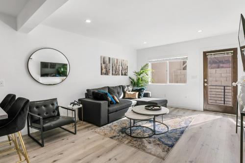 a living room with a couch and a table at Muirfield Chic City Bungalow with Parking in Los Angeles
