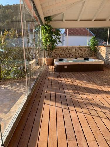 a patio with a hot tub sitting on a deck at Villa Kamelicina in Vinišće