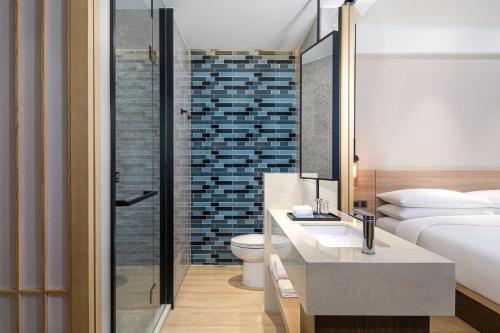 a hotel room with a bathroom with a toilet and a sink at Fairfield by Marriott Shanghai Pudong Central in Shanghai