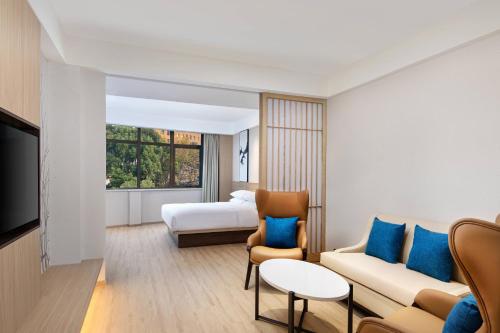 a hotel room with a couch and a bed at Fairfield by Marriott Shanghai Pudong Central in Shanghai