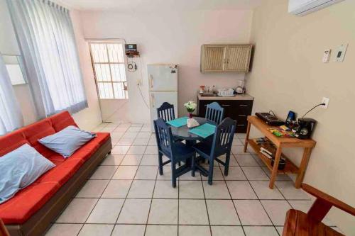 sala de estar con sofá rojo y mesa en Casa Laguna Milagros, a 20 minutos de Bacalar en Chetumal