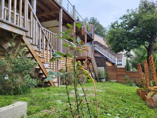 a house with a wooden staircase in a yard at Le Bellevue - Beaux appartements avec vue splendide in Palaiseau