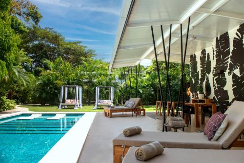 an outdoor patio with a swimming pool and a pool house at La Prometida in Puerto Viejo