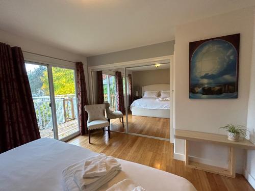 North Nanaimo Gem - Garden-View Room with Private Ensuite في نانايمو: غرفة نوم بسرير ونافذة كبيرة