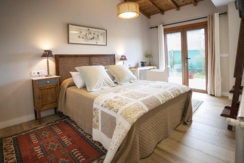 a bedroom with a bed with a table and a window at Casa Regente in O Viso