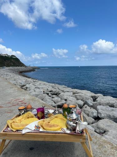 uma mesa com comida ao lado do oceano em my_tangier_ em Tânger