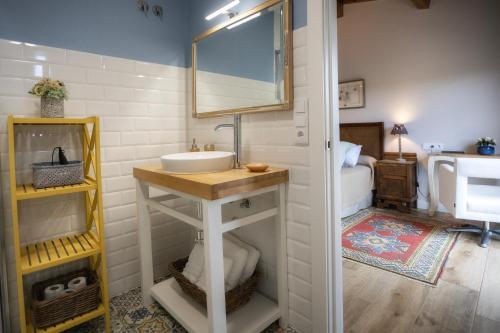 baño con lavabo, espejo y cama en Casa Regente, en O Viso
