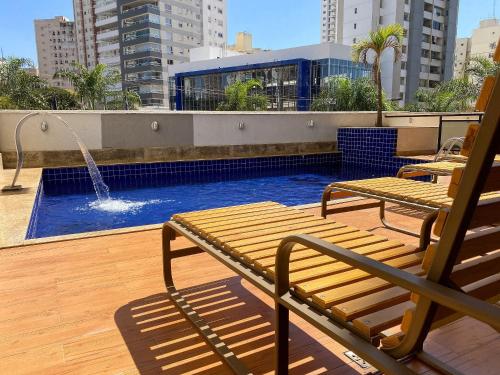 uma piscina com dois bancos e uma fonte num telhado em STAY Sun Square em Goiânia