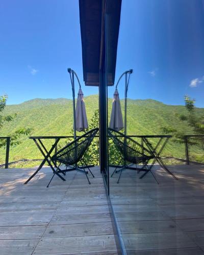 two chairs and an umbrella on top of a deck at Woodpecker Georgia in Batumi