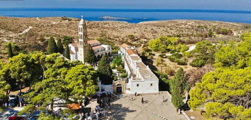 a large white church with a steeple on a hill at Cantera house, Kalokairines KIT in Kythira