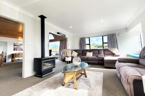 ein Wohnzimmer mit einem Sofa und einem Kamin in der Unterkunft Hosts on the Coast Whiti Te Ra Sunrise in Whitianga