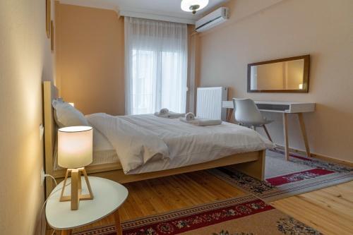 Schlafzimmer mit einem Bett, einem Schreibtisch und einem Tisch in der Unterkunft Zennova #5 Antigonidon Square in Thessaloniki