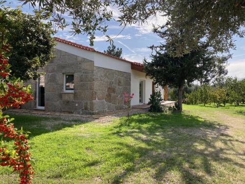 a view of a stone house with a yard at Casa Ar da Beira - Serra da Estrela - Belmonte in Belmonte