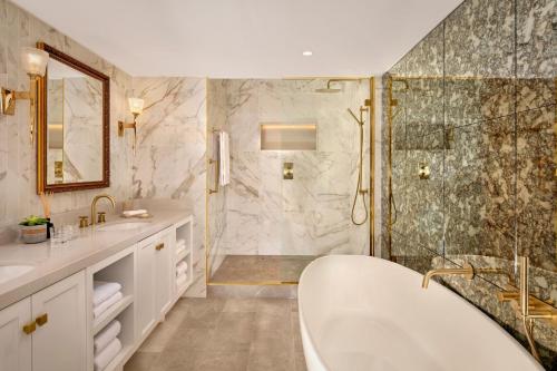 a large bathroom with a tub and a shower at The College Green Dublin Hotel, Autograph Collection in Dublin