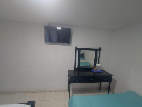 a bedroom with a mirror and a black dresser with a tv at Hotel Rosandy Galaxy in Cartagena de Indias