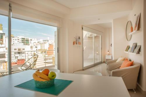 a living room with a table with a bowl of fruit at Báltico Suites in Buenos Aires