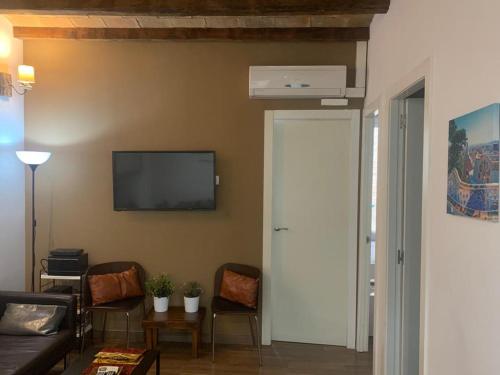 a living room with a couch and a tv on the wall at Apartament modern al carrer Blai, Poble Sec in Barcelona