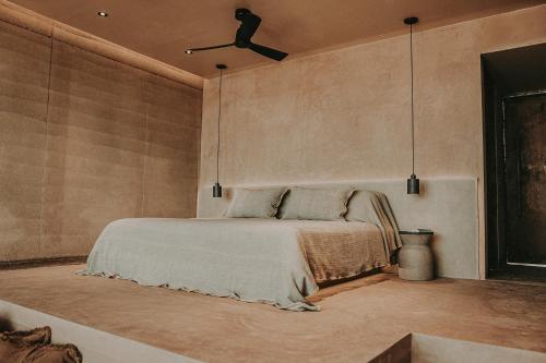 - une chambre avec un lit et un ventilateur de plafond dans l'établissement MIRA Earth Studios, à San Antonio de las Minas