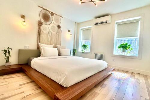 1 dormitorio con 1 cama grande con sábanas blancas en Bright, airy, luxe hideaway”w” private backyard, en Brooklyn