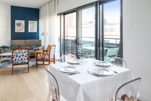 a dining room with a table and chairs and a living room at La terrasse d'Issy - Welkeys in Issy-les-Moulineaux