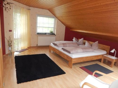 a bedroom with a large bed with a wooden ceiling at Chefs Gästezimmer in Neupotz