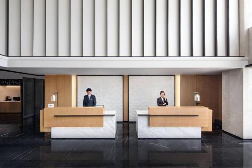 two people sitting at desks in a lobby at Fairfield by Marriott Kunming Xinying in Kunming