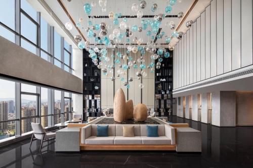 a lobby with a couch and a chandelier at Fairfield by Marriott Kunming Xinying in Kunming