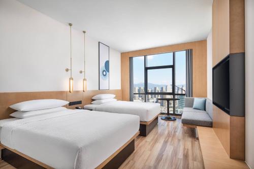 um quarto de hotel com duas camas e uma televisão em Fairfield by Marriott Kunming Xinying em Kunming