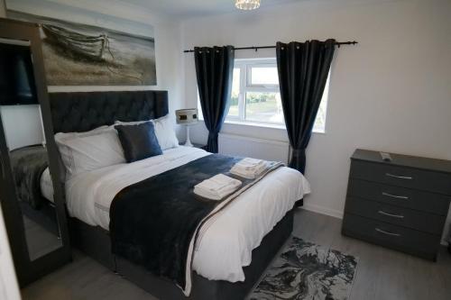 een slaapkamer met een groot bed en een raam bij Giomakay luxury Rooms Milton Keynes in Milton Keynes