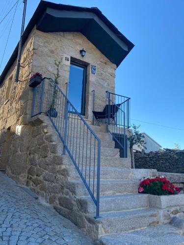 ein Steinhaus mit einer Treppe, die zu einer Tür führt in der Unterkunft Casa Fina in São Pedro do Sul