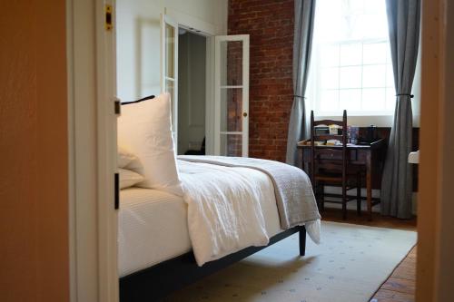 a bedroom with a bed and a table and a window at Imperial Hotel + Restaurant in Amador City
