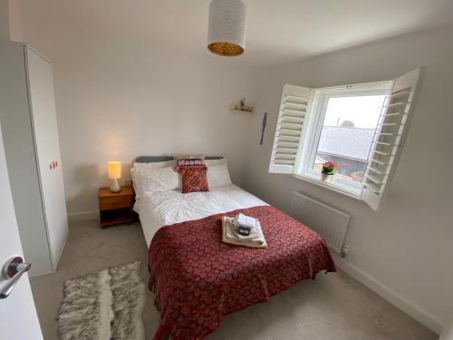 a small bedroom with a bed and a window at New Comfy Family Friendly home in Canterbury in Sturry