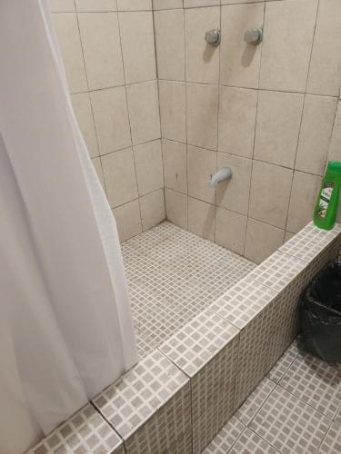 y baño con ducha y suelo de baldosa. en Recamara confortable en San Nicolás, en Monterrey