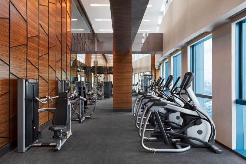 a gym with rows of exercise equipment and windows at Sheraton Beijing Lize Hotel in Beijing