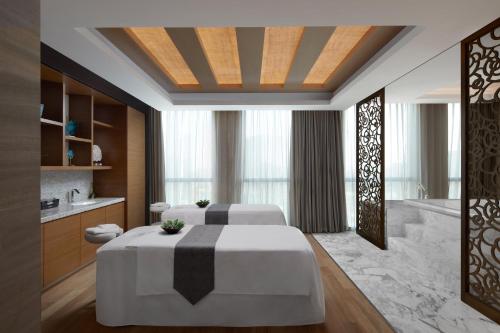 a hotel room with two beds and a bath tub at Sheraton Beijing Lize Hotel in Beijing