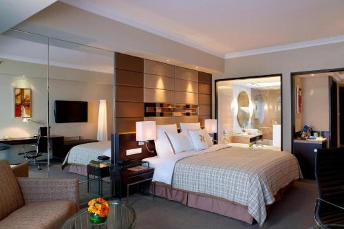 um quarto de hotel com duas camas e um sofá em Four Points By Sheraton Beijing, Haidian em Pequim