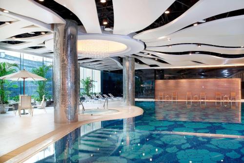 una hall con piscina, tavoli e sedie di Four Points By Sheraton Beijing, Haidian a Pechino