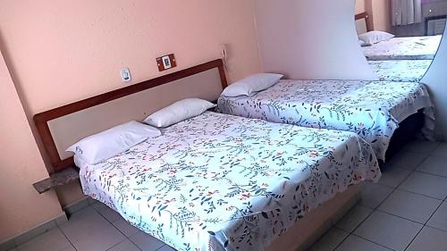 two beds in a small room with at Hotel Fênix in Salvador