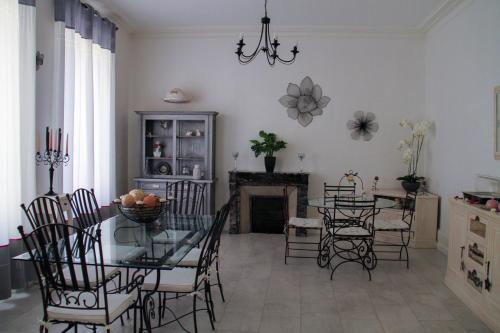 comedor con mesa de cristal y sillas en La Maison de Vénus, en Luçon