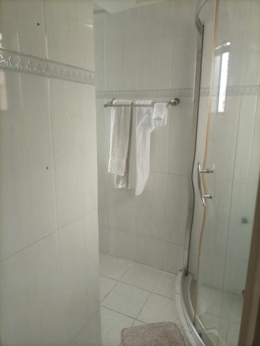 a white bathroom with a shower and towels at Executive Suite Apartment in Nairobi